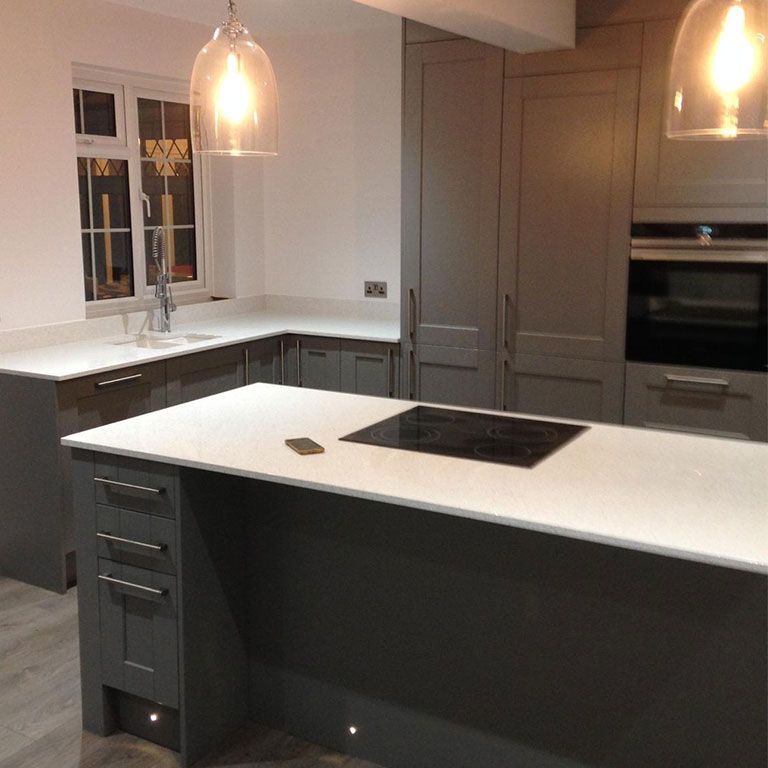 High-end fitted kitchen with a central island and pendant lights fitted during a house refurbishment