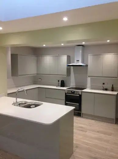Grey fitted kitchen with a range cooker set into the chimney breast