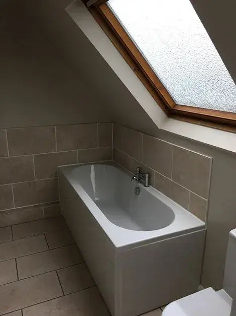 Freestanding bath positioned under a skylight in a converted loft