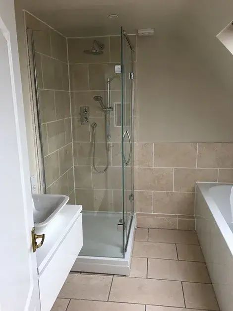 Tiled walk-in shower with a glass screen in a newly refurbished bathroom